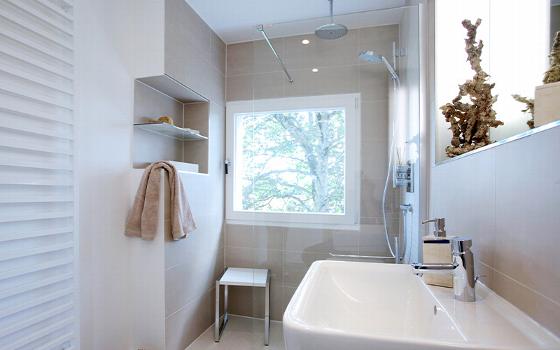 modern bathroom with large window light wood accents and shower area showcasing three design elements