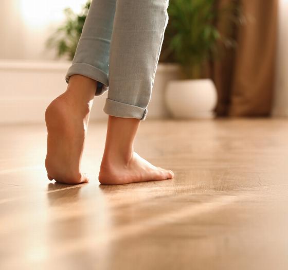 person in gray socks sitting on floor wearing blue jeans with a cozy sweater relaxing at home