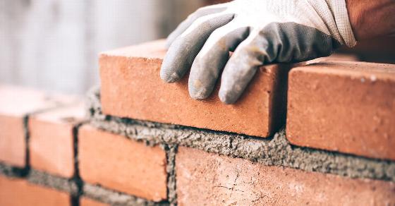 happy couple shaking hands with real estate agent in an interior setting discussing property options
